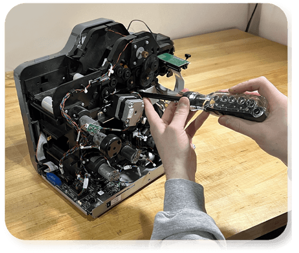 A K&A technician repairing a card printer represents End-to-End Printer Support with Logistic service from K&A.