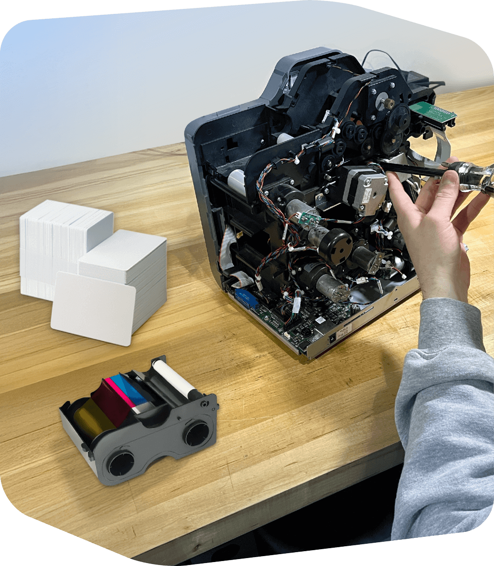 Printer being repaired, stack of ID cards and printer ink