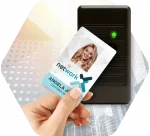 A hand holds a corporate ID card up to a card reader